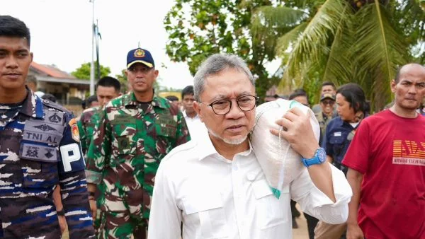 Menteri Koordinator Bidang Pangan Zulkifli Hasan saat memanggul karung beras ketika meninjau korban banjir di Sumatra (Dok : Int).