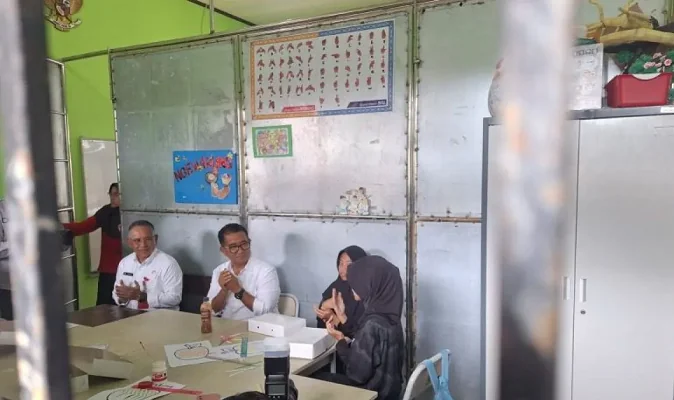 Pj Gubernur Kaltim Akmal Malik mencontohkan kepada dua siswi SLBN Balikpapan untuk terlebih dahulu membaca doa sebelum menikmati santapan menu makan bergizi gratis. DOC: (ANTARA)
