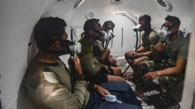 Prajurit Batalyon Intai Amfibi-1 Korps Marinir TNI AL (Yontaifib-1) duduk di dalam ruangan dekompresi (chamber decompression) milik Yontaifib-1 usai melakukan penyelaman dalam operasi SAR pesawat Sriwijaya Air PK-CLC nomor penerbangan SJ 182 di Pantai Tan